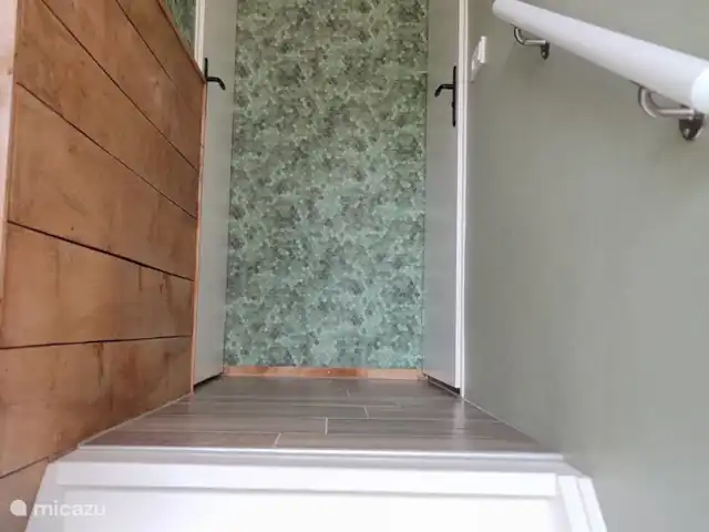 De opgang naar boven. Links de masterbedroom, rechts de volledige badkamer met toilet. De wasmachine is beneden.